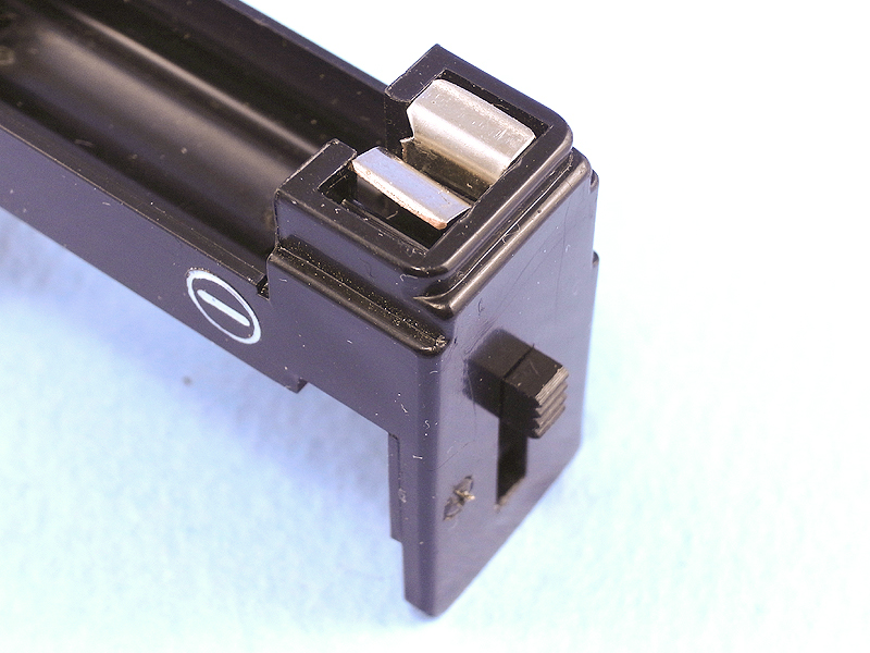 あらためて部品を組み直すとスイッチが完成する。これは電源オフ状態。金具の間にフラッシュバルブ排出レバーが挿入され、隙間ができて通電しない。