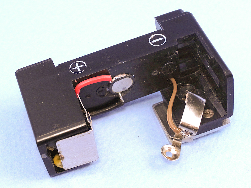 発光部と昇圧回路を再び組み込み、マイナス側の電気接点にコードを半田付けする。コードのレイアウトはあらかじめタイトに決めておかないと、部品が本体からはみ出してしまう。