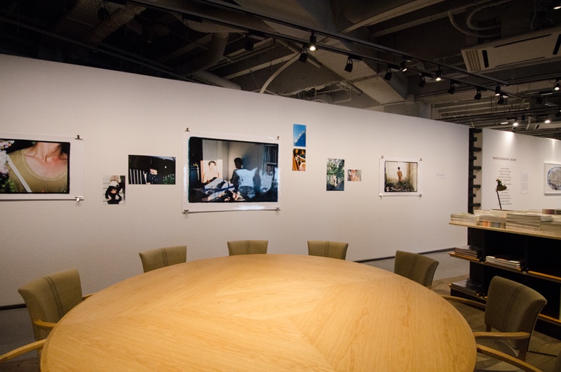 座り心地のよい椅子に大きな丸いテーブル。その向こうの壁面はギャラリーとはまた別の展示スペースです。現在は、森栄喜氏の木村伊兵衛賞受賞作品が展示されています。