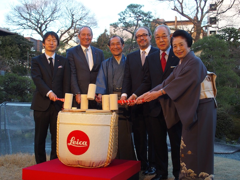 日本庭園を背景に、ライカロゴのついた酒樽で鏡開き。オープニングレセプションの一幕