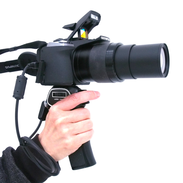 24-1,200mm相当の50倍ズームを装備し、カメラとして世界で初めて「ドットサイト」(照準器)を搭載した「OLYMPUS STYLUS SP-100EE」に、ニコン製「ガングリップ」を装着。まるでSF映画に出てくるレーザーガンみたいで、思った以上にカッコ良くなった(笑)。機能的には、専用のリモートケーブルを改造することによって、グリップのトリガーでシャッター半押しとレリーズ操作を可能とした。文字通り銃のように構え、ドットサイトで狙いを定め、1,200mm相当の超望遠ズームで撃つ! と言ったスタイルだが、カメラの安定性も増して実用性はなかなかのものだ