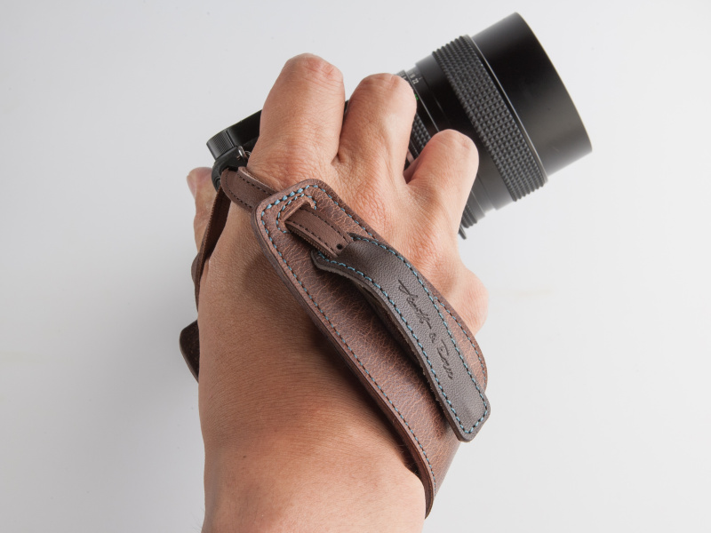 手の甲を覆うようにストラップに手を通す。カメラと手の一体感が増す