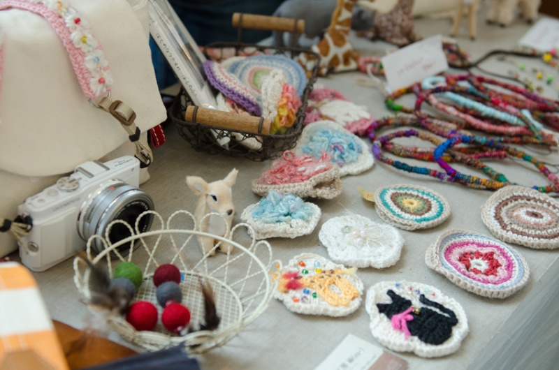 コサージュ？　バッジ？　何かと思えばレンズキャップケースだそうです。デザインも機能もよく考えられています。（工房 絲）