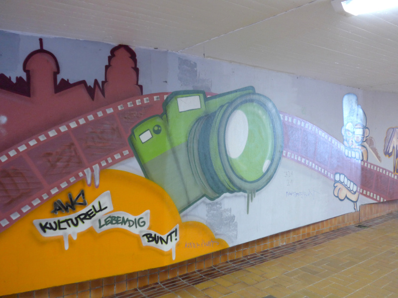 ライカマイクロシステムズ前の地下道。壁面にカメラとフィルムの絵が描かれていた