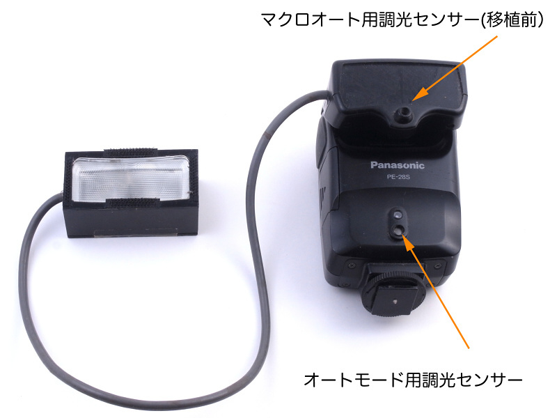 今回はこの改造マクロストロボを、さらに改造しようと思うのだが、その前にもうちょっと当時の工夫について述べてみたい。ベースとなったストロボはパナソニック「PE-28S」(生産中止品）で、発光部を取り外しコードで延長する改造を施している。PE-28Sは通常の「外光オート用調光センサー」の他に、「マクロオート用調光センサー」(矢印部分）を備えているのも特徴だが、この箇所にも改造を施している
