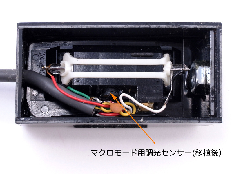 この写真ではわかりづらいのだが、これ以上分解してお見せすると壊してしまいそうで、申し訳ない。実はストロボ発光部の反射鏡に穴を空け、その内側に本体から取り外した「マクロオート用調光センサー」を取り付けている。これによってセンサーはストロボ光を“直”に受ける事になり、発光量は常に最小に制御される。このセンサーの改造は、当時の連載ではスペースの都合上書く事ができなかった内容で、今回はどうしても書きたかったのだ(笑)