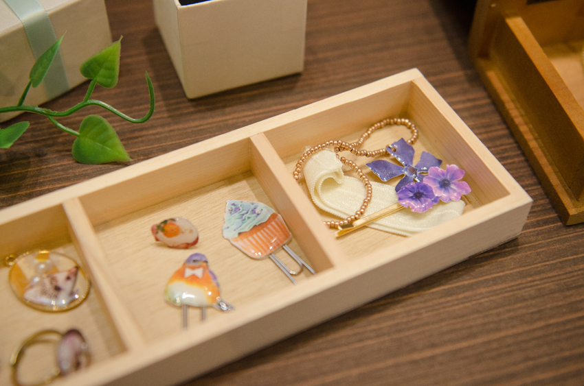 写真を使ったレジンクラフト。小さく切り抜かれた花や動物のプリントが透明樹脂でぷっくりとコーティングされて、可愛らしく仕上がっています。