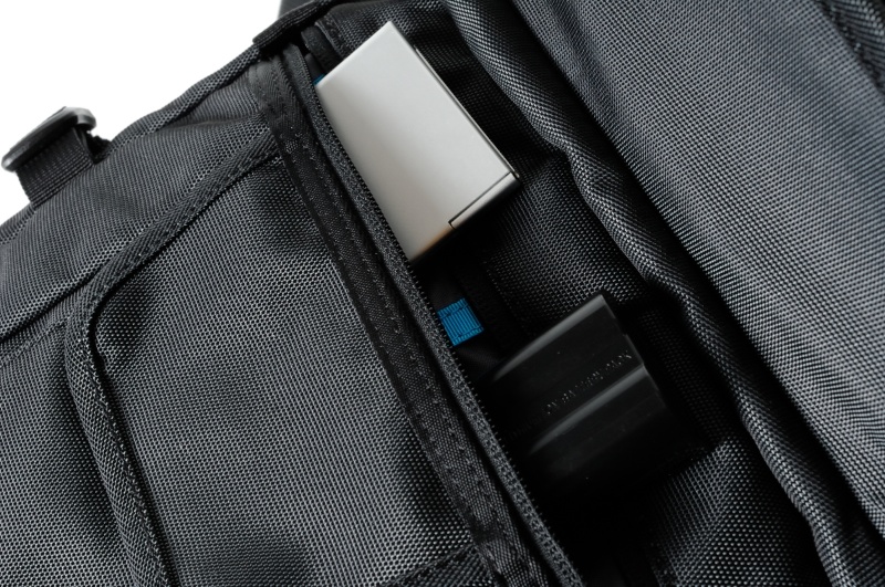 奥のフロントポケットは仕切りがあるので予備バッテリーやカードケースなどを収納できる