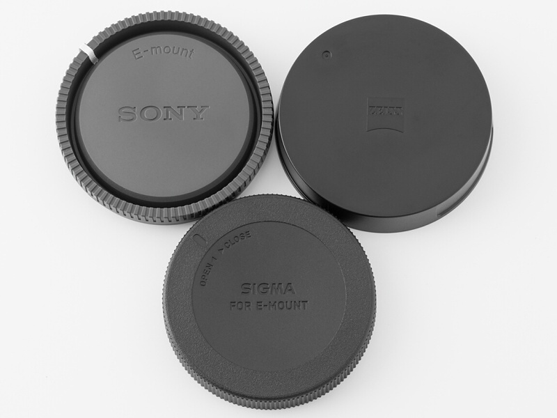 Eマウント用のリアキャップ。右上がカールツァイス、左上がソニー純正、下がシグマ。それぞれレンズに付けたときの締まり感が微妙に違う