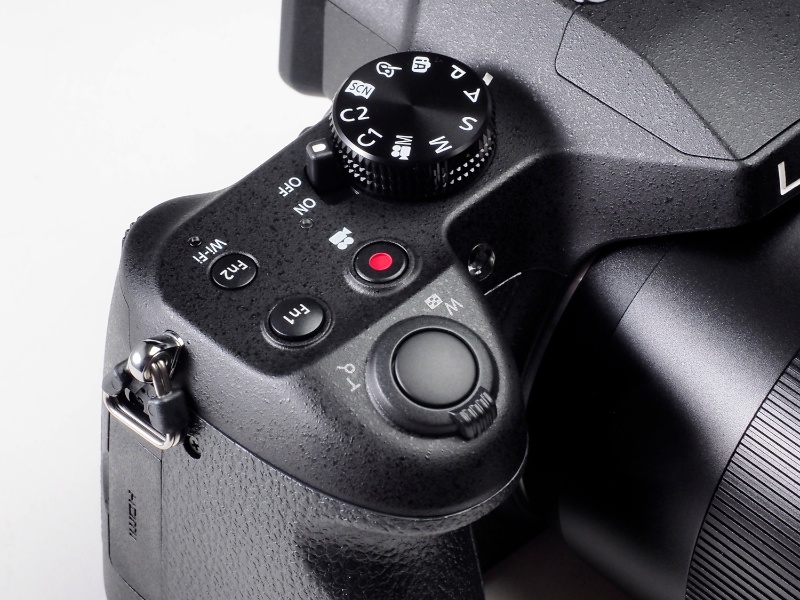 シャッターボタン周辺にはコンパクトデジタルカメラらしくズームレバーが搭載される。電源スイッチはモードダイヤルと同軸で搭載されている。