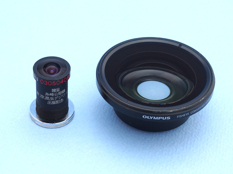 そこで登場するのが魚露目8号（左）である。デジカメ用魚眼コンバージョンレンズとしては、レンズ径約15mmと非常にコンパクトなのが特徴だ。隣のFCON-T01と較べるとその差は歴然だ。魚露目8号のこの小ささが、昆虫撮影に非常に有利なのである。ところで、ぼくの魚露目8号は「進呈 糸崎公朗様 東京昆虫デジワイド 出版記念」とプリントされたスペシャルバージョンなのだが（笑）そのわけは……