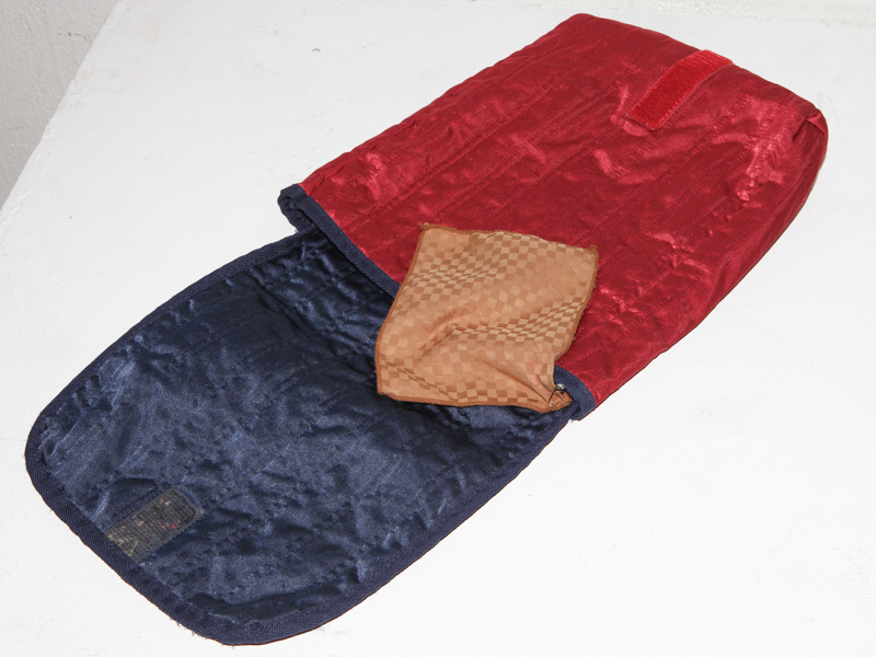 機材を包むキルティングポーチの内側にレンズ拭きを安全ピンで付けるというアイデアを教えてくれた。「レンズ拭きは無くしやすいのでこうしておくと便利です」