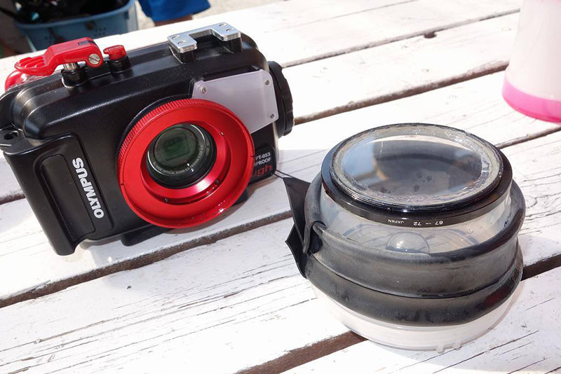 OLYMPUS STYLUS TG-2 Tough用の機材。宙玉のボディ側にも丸いアクリル板が取り付けられ、空気が入らないようになっている。ハウジングの赤いリングの部分は海水が入ってもオーケーなので、シリコンじょうごは不要だ