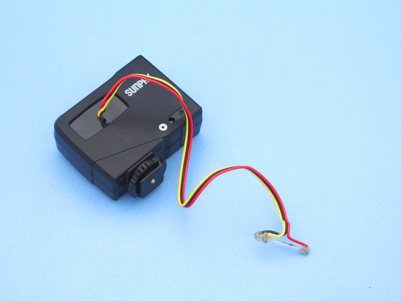 ストロボは『<a href="http://dc.watch.impress.co.jp/docs/review/labo/20090604_212408.html" class="n" target="_blank">「超高倍率マクロ」のストロボシステムを考える</a>』の記事で使用したものをいったんバラし、再利用する。サンパック「PF20XD」から発光部を摘出し、コードで延長している。接点は樹脂（グルーガン）で固めているため感電の心配は無い。