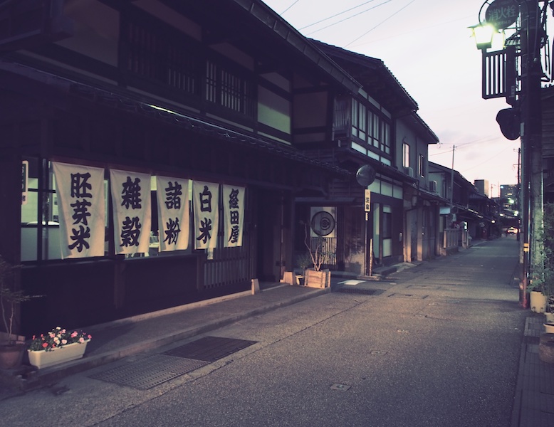 日本的な茶屋街の夕暮れ、露出補正をマイナス1にしてさらにシックに演出しました。車のヘッドライトが路地を照らしている所を撮影しました