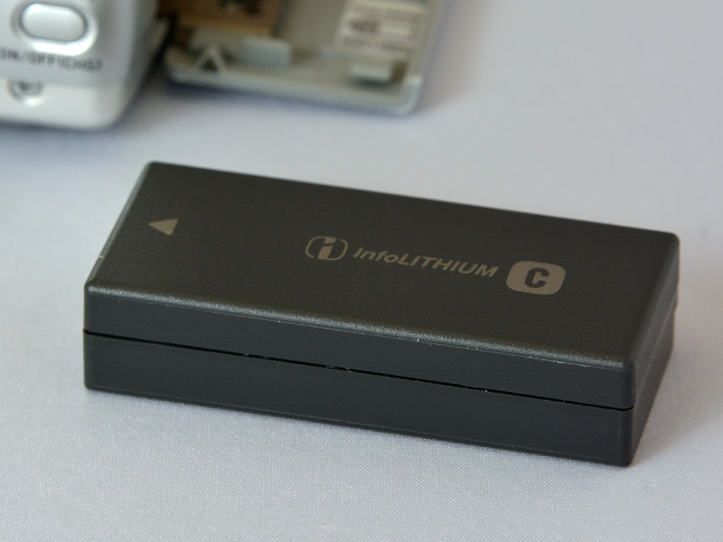 使用電源は、付属の充電式リチウムイオン電池、Cタイプ「NP-FC10」。板ガムや「都こんぶ」を小さくしたような形状。この電池を抜くと、日付・時刻がリセットされてしまう。内蔵の充電式ボタン電池がすでにダメになっているのだろう。