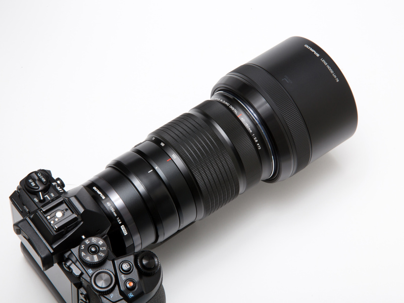 専用フードは大きめ。深さもあり有害な光をしっかりとカットしてくれる。レンズに取付けた状態のまま伸縮させることが出来るので、不要な場合やカメラバッグへの収納時などには簡単に縮めることができる。スライドロックは回転式でフードの中程に位置する