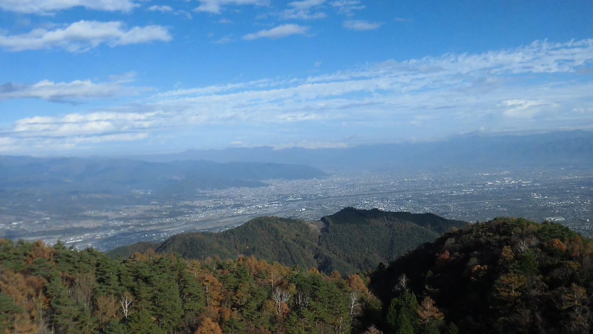 山頂の木立を越える高さに上げてみると霞んだ街並がなぜか嬉しい。