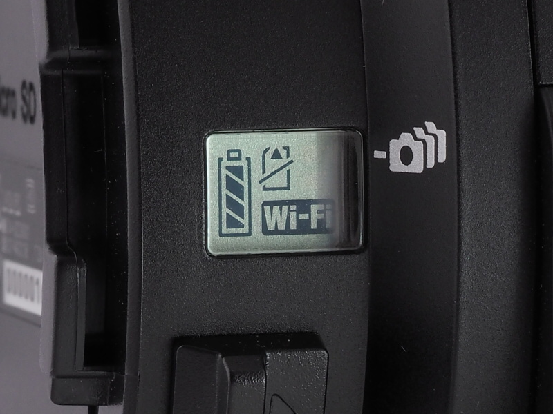 本体側面の液晶には、Wi-Fi接続や電池残量、記録カード用警告などが表示される。下のレバーはアタッチメント解除用