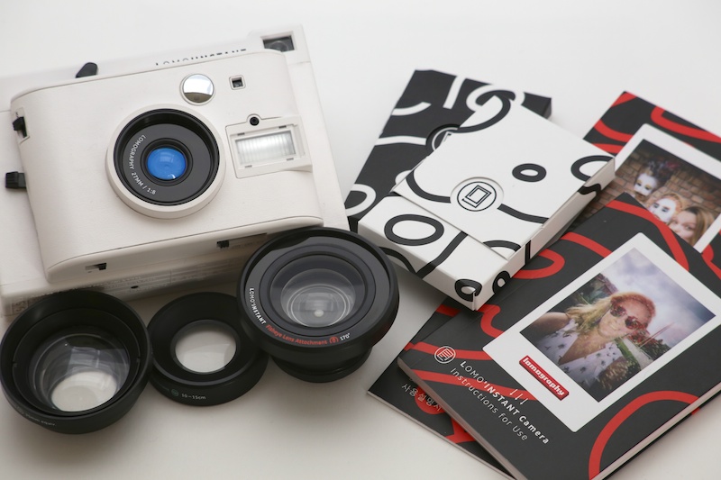 「LOMO'INSTANT CAMERA WHITE +3 LENSES」（税込1万6,800円）の同梱物。カメラ本体、フィッシュアイレンズアタッチメント、ポートレートレンズアタッチメント、クローズアップレンズアタッチメント、そして、4色のカラーフィルターなど。