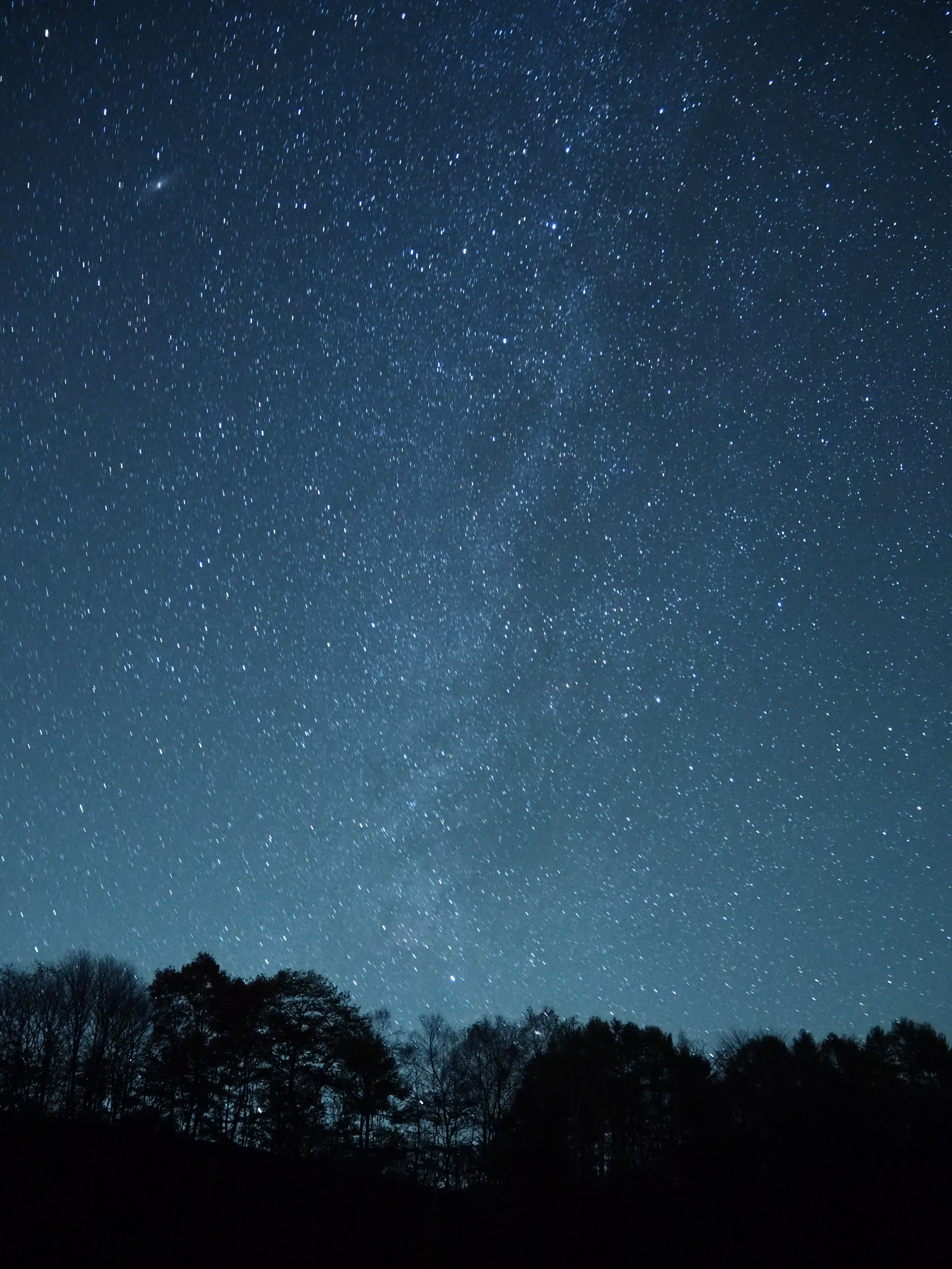 ホワイトバランスをマニュアルで3200Kにセット、クールな感じの青い夜空にしてみた。コントラストを高く設定することで、刷毛ではいたような秋の天の川の表情をとらえることができた。画面左上にはアンドロメダ銀河が見えている。<br class="">OLYMPUS OM-D E-M10／M.ZUIKO DIGITAL ED 14-42mm F3.5-5.6 EZ／ISO3200／F3.5／60秒／14mm／WB:マニュアル（3200K）／コントラスト+2