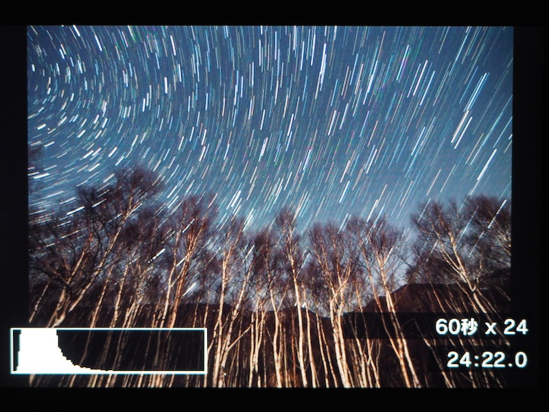 オリンパスのライブコンポジットでは、星の光跡が伸びる様子をリアルタイムで見ながら撮影ができる。これは月明かりで照らされた白樺林に昇る星々を7mmのレンズで撮影しているところ。ヒストグラム、設定秒数と撮影コマ数、経過時間がモニターに表示される。
