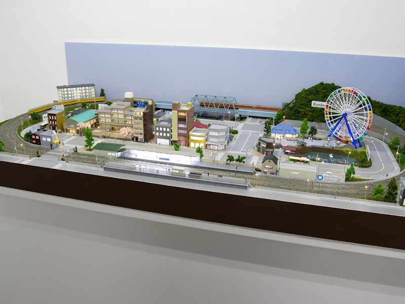 フィルター試し撮りコーナーには鉄道模型が走る。現本社のKT中野ビルを模した建物もあった