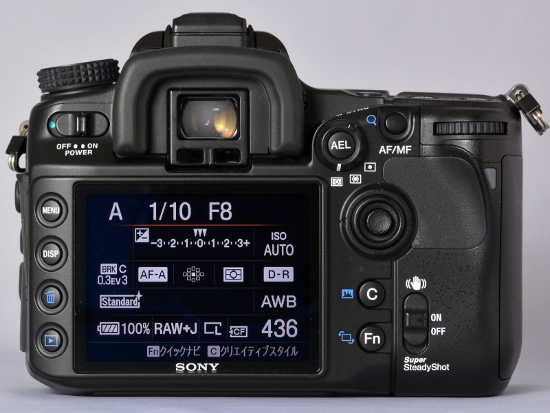 ソニーでの“初代α”になるα100と比べると、戦闘的というかシャープでキレのあるデザインのα700ボディ。正面から見た際のペンタ部のハッキリしたラインや、ホールド感を高めるために大きくえぐられたグリップ部、ジョイスティック感覚で操作できるマルチセレクターの配置（背面側）。そういったデザインや仕様の違いに、α100とは違う“ミドルクラス機のとしての風格”が漂う。