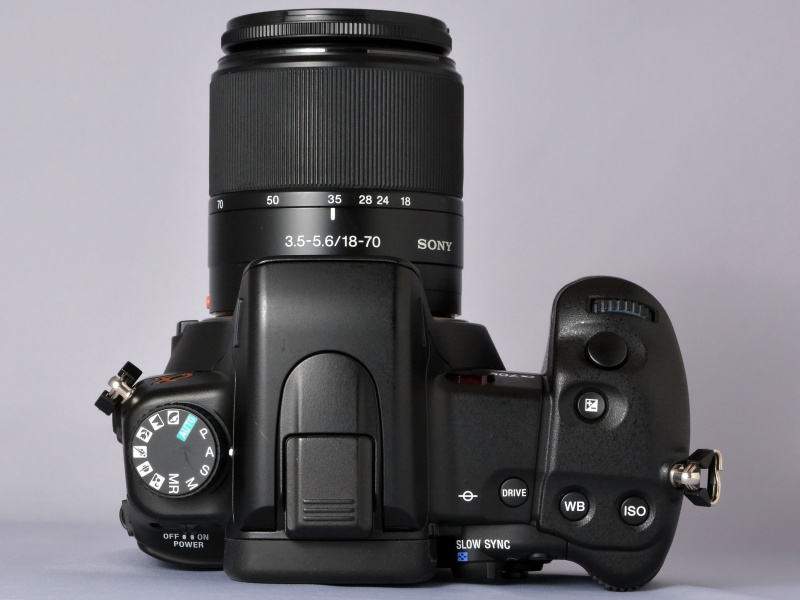 ソニーでの“初代α”になるα100と比べると、戦闘的というかシャープでキレのあるデザインのα700ボディ。正面から見た際のペンタ部のハッキリしたラインや、ホールド感を高めるために大きくえぐられたグリップ部、ジョイスティック感覚で操作できるマルチセレクターの配置（背面側）。そういったデザインや仕様の違いに、α100とは違う“ミドルクラス機のとしての風格”が漂う。