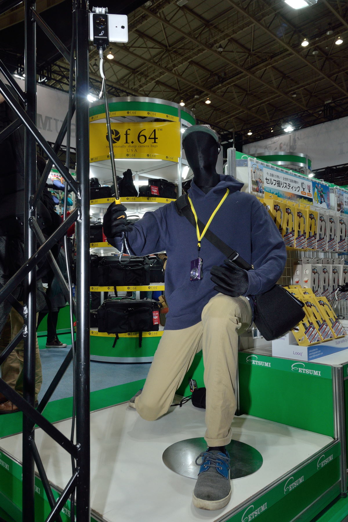 自分撮りスティックを使うマネキン。HARRIS TWEEDショルダーを提げている