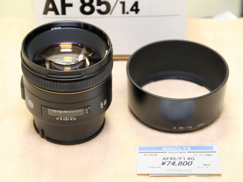<strong class="">ミノルタAF85mm F1.4G</strong><br class="">ミノルタαシリーズの大口径中望遠レンズ。製品名末尾のGは高級レンズである証し。写真のアイテムはフードのほか、元箱も付属。（ペンギンカメラ）