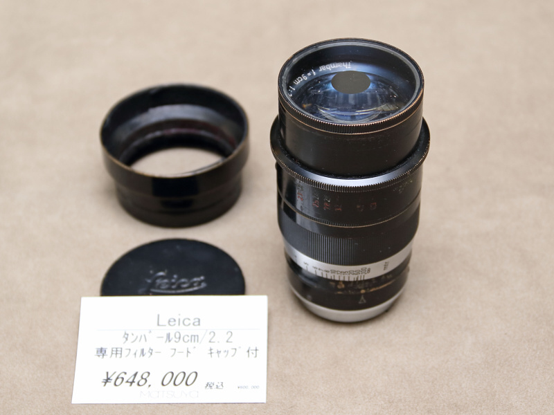 <strong class="">ライカThambar 9cm F2.2</strong><br class="">タンバールは、専用のフィルターによってレンズの中心に光を通さないようにし、収差の大きい周辺部のみで結像させることで独特のにじみやボケが得られるレンズ。フィルターを外したときのために、レンズには2つの絞り値が刻まれている。（新橋イチカメラ）