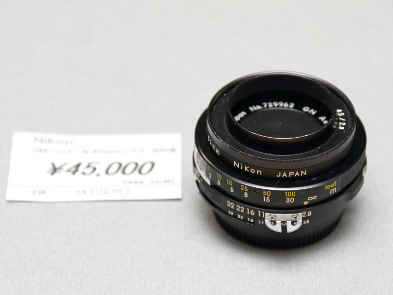 <strong class="">ニコンGN  Nikkor 45mm F2.8</strong><br class="">テッサータイプのパンケーキレンズ。GNとは、絞りとフォーカスリングがストロボのガイドナンバーに連動する機構を備えることから。本レンズ自体はさほど珍しいものではないが、ピックアップしたレンズには、貴重なフードが付属する。（秀光）