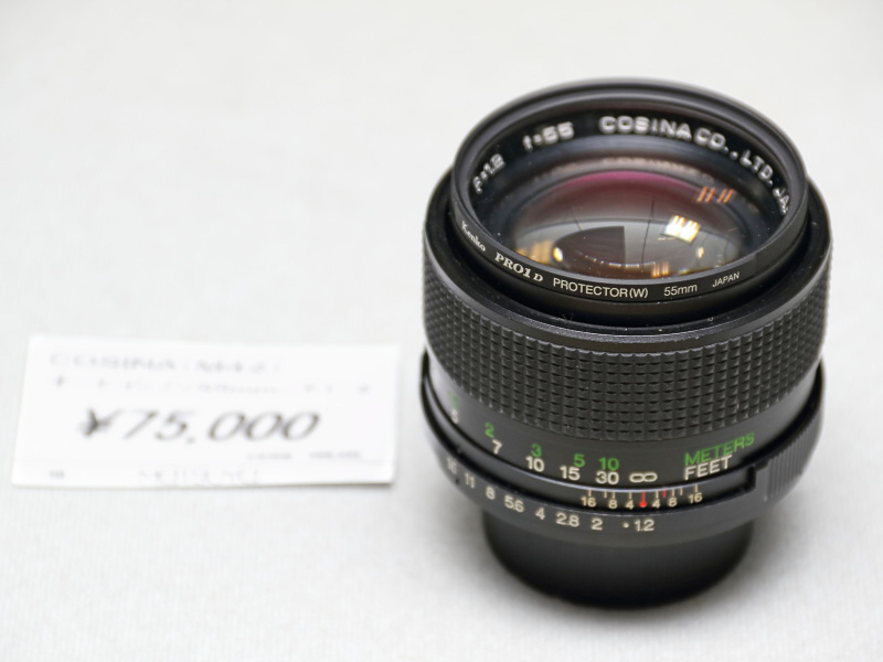 <strong class="">コシナCOSINON 55mm F1.2</strong><br class="">富岡光学の製造といわれるコシナの大口径標準レンズ。スクリューマウントゆえ開口部が狭く、しかも信号ピンを鏡筒内から出すために、後玉の一部は大胆にもカットされている。開放のとろけるような描写を味わいたい。（秀光）