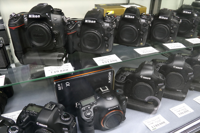 中古のデジタル一眼レフをショーケースに並べるショップも多い。フラッグシップ機をはじめ手頃な値段で購入できる。そのほかミラーレスや高級コンパクトデジタルなどの中古も多数見受けられた。（アカサカカメラ）