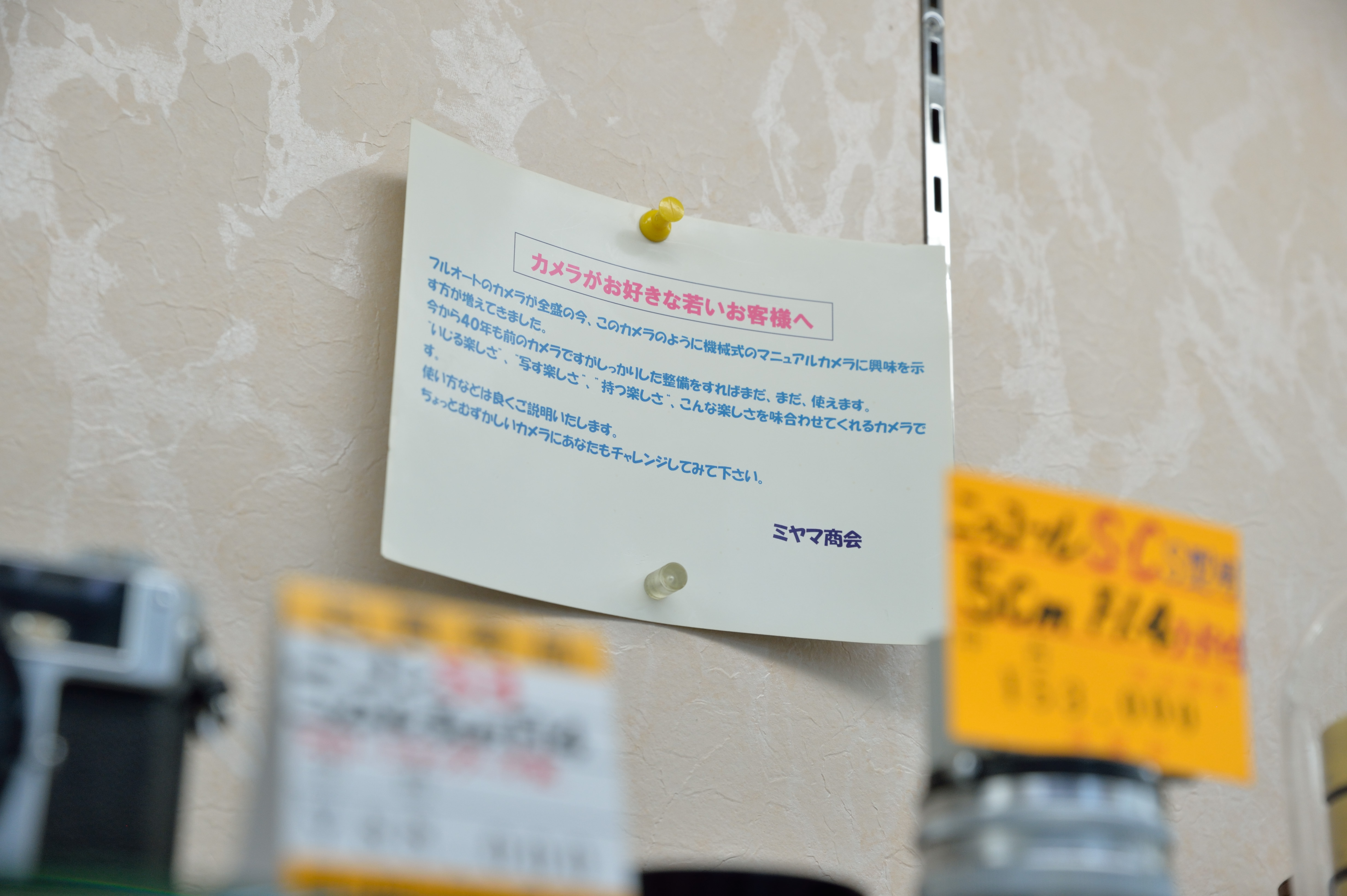ショーケースのなかで見かけた貼り紙。機械式マニュアルカメラに興味ある若い客に向けてのものであるが、同店の心意気を感じさせる。分からないことがあったら積極的に尋ねてみたい。
