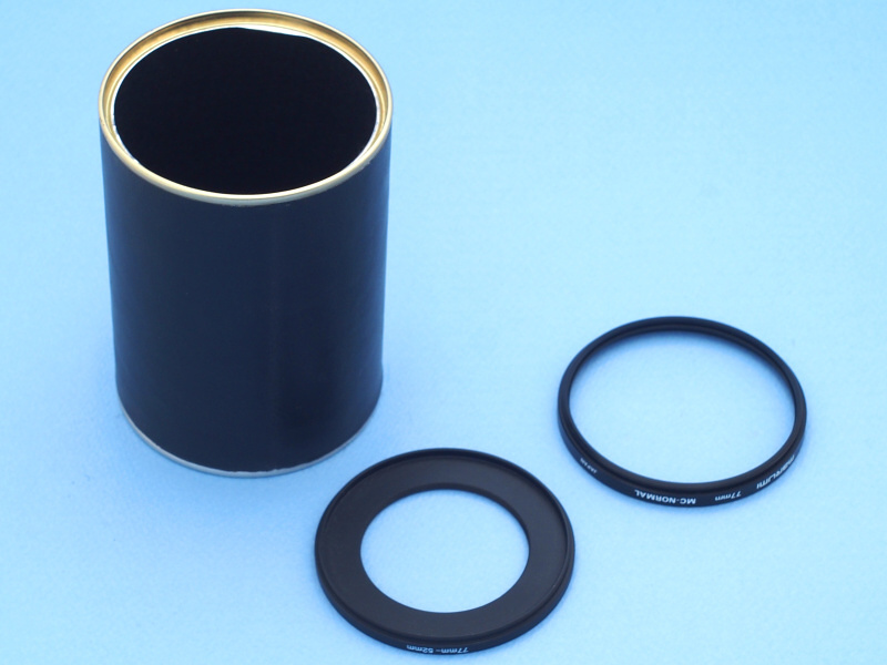 ちょっと心配だったが、なかなか上手い具合に革を貼ることができた。接着剤を薄く塗っただけなので、表面の凸凹もなく、剥がれる心配もなさそうだ。エッジ部分は缶のスチル素材を活かしてみたが、この処理も上手くいったようだ。次にレンズへの装着だが、77mm→52mm径ステップダウンリング（中）と77mm径フィルター枠（右）を併用することにした