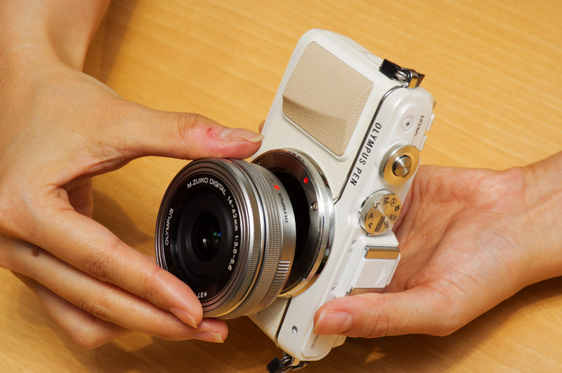 レンズをつけるときは、レンズとカメラボディのそれぞれにある、赤い丸を合わせます（カメラによっては赤色ではないときも）。あとは外す時と逆にレンズを回します。「カチッ」というまで回してください。