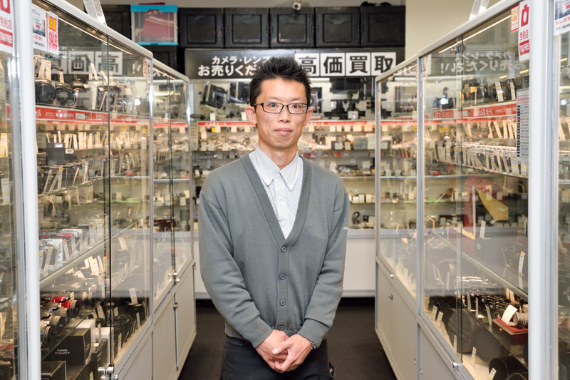 今回お話を伺った株式会社ナニワ商会心斎橋本店の池田高博さん。「最新デジタル一眼からオールドカメラまで、さらに交換レンズなど積極的に買い取りいたします。カメラや交換レンズを処分されるときは、お気軽にご相談ください」