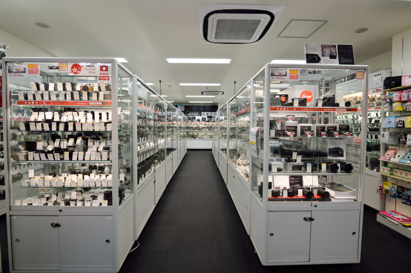 カメラのナニワ心斎橋本店の様子。ショーケースにはずらりと中古のカメラ、交換レンズなどが並ぶ。