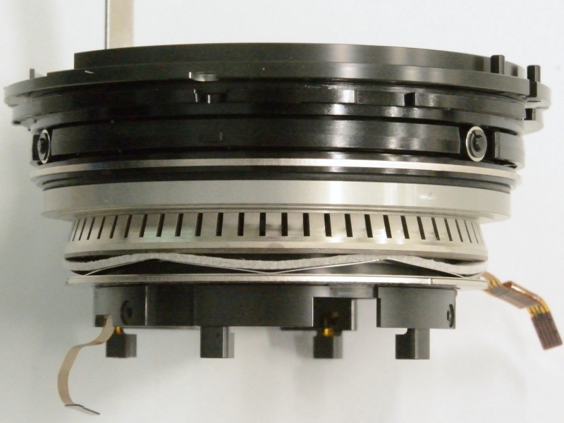 <strong class="">リング型の超音波モーター</strong><br class="">静粛で高速なレンズ駆動を可能にする超音波モーターを採用。リング式の超音波モーターは、径が限られているため、その内径にVCユニットをいかに収めるかが課題だったという