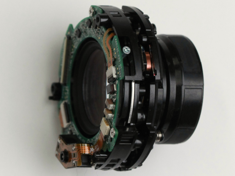 <strong class="">手ブレ補正ユニットの仕組み</strong><br class="">VCレンズの周りに駆動コイル、それを挟み込むシャーシ側にマグネットを配置し、磁力を利用して補正光学系を駆動。マグネットをダブルにして駆動力アップを図っている