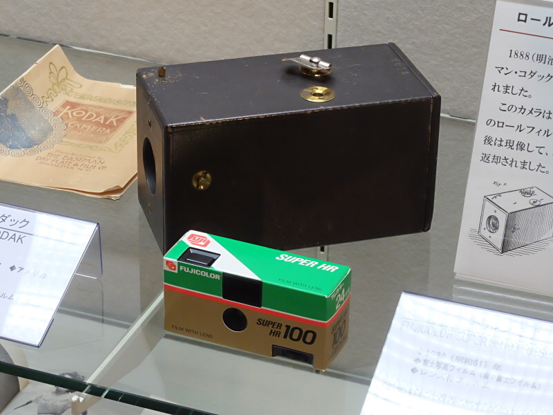 撮影後に箱ごと現像に出す「ザ・コダック」（奥。1888年）と、同様のシステムで現在まで続く富士フイルムの「写ルンです」（手前。1986年）