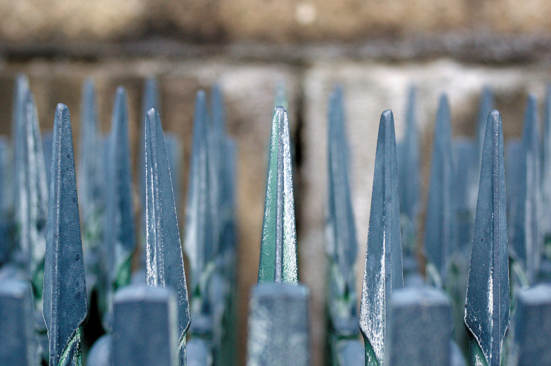 金属製の柵。中央の先端にしっかりとピントが合っていて、金属の錆びた質感がよく出ている。