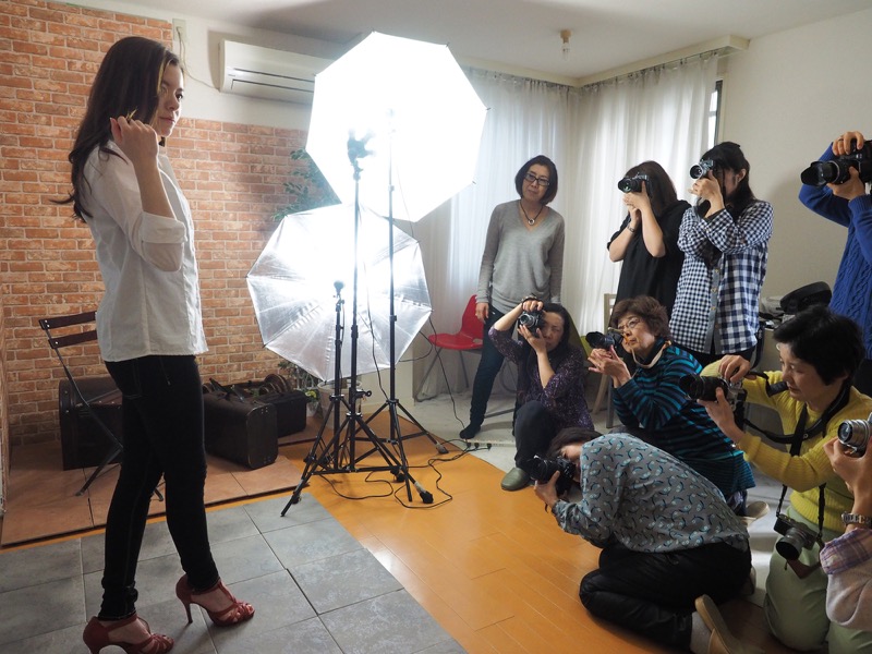 コンクリート風の壁のシチュエーションでは、白シャツと黒パンツ、赤いヒールというスタイリッシュな衣装で撮影。イメージに合わせ、陰影が出やすい強めのライティングにしました。