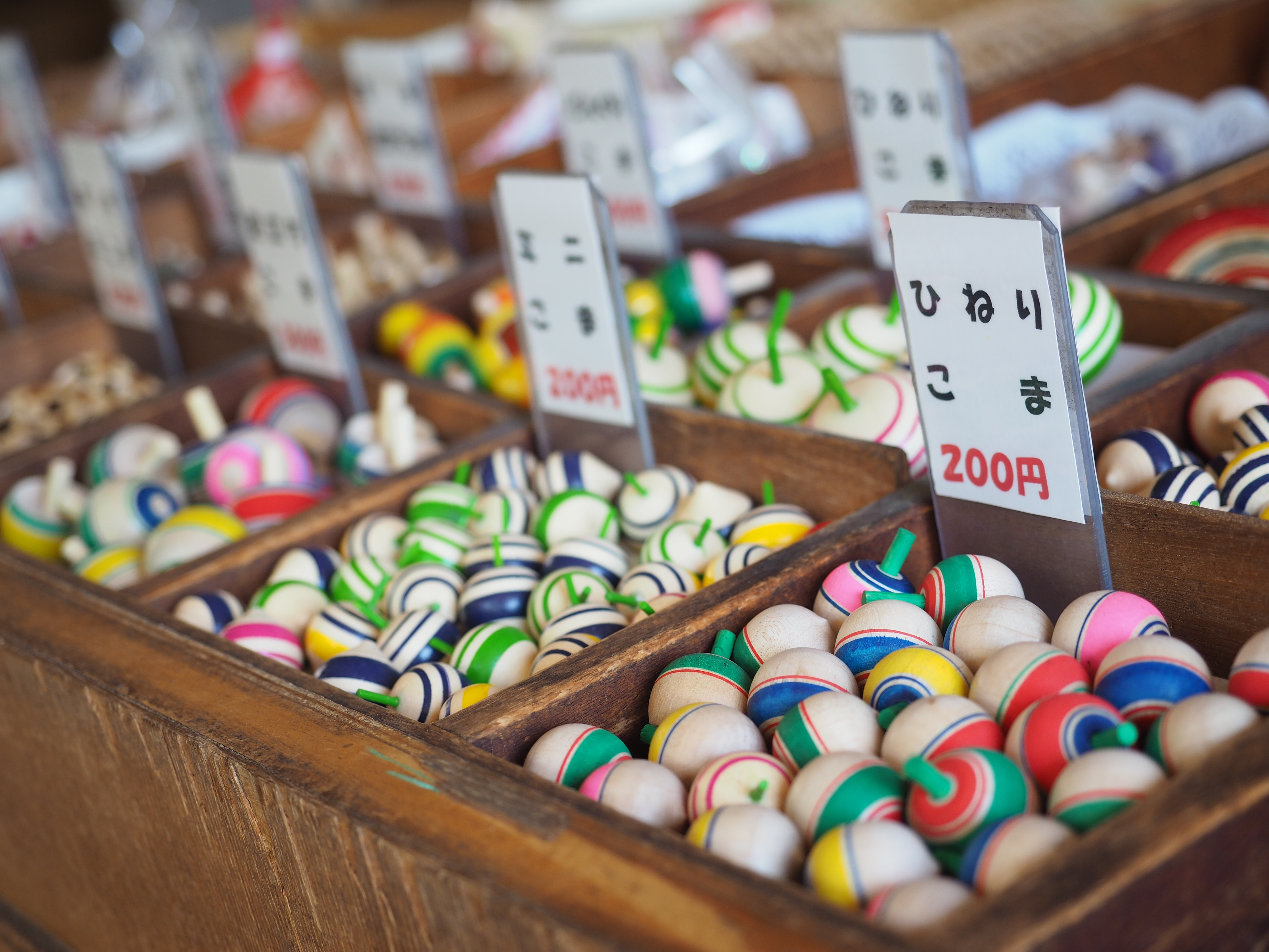 たくさんのカラフルな駒がお店を彩っていました。奥行き感を出すために水平アングル気味にカメラを構えて、カラフルなコマが並ぶ様子を切り取りました。撮影：コムロミホ先生