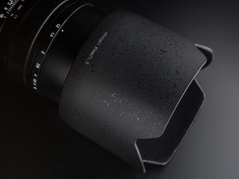 レザートーン塗装を施した花型フードが付属する。レンズへの取り付けはバヨネット式だ