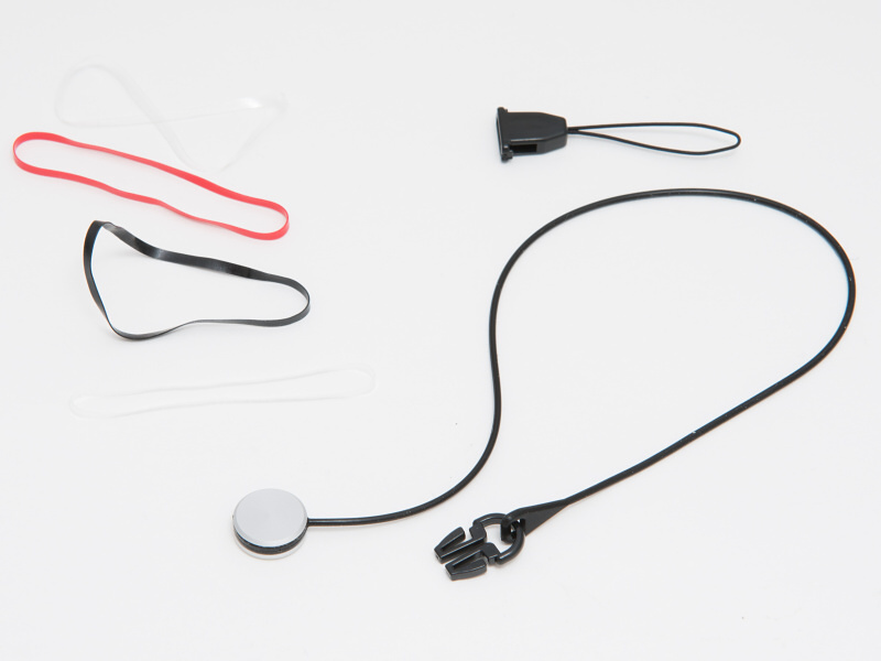 BLaKPIXELのレンズキャップホルダー。ヘッド部分とボディ側の接続バックルや、4本の輪ゴムがセットになっている