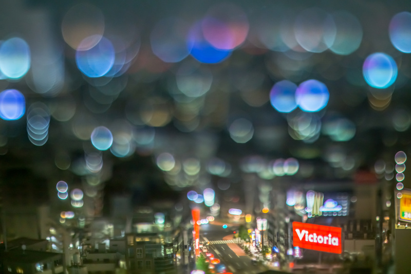 カメラにぶつけないようレンズ上端の位置を指で支えて、レンズの下側を上に持ち上げる