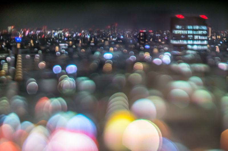 手のひらでレンズ下端を支えてレンズとカメラをへの字に曲げる。上の写真は左と同じ場所から撮影している